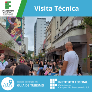 A imagem mostra um grupo de pessoas sentadas e em pé na Rua Felipe Schmidt, no centro de Florianópolis. No topo da imagem, há um banner azul com o texto "Visita Técnica." No canto superior esquerdo, está o logotipo do Instituto Federal Catarinense. Na parte inferior da imagem, há um banner azul claro com o texto "Técnico Integrado em Guia de Turismo" e o logotipo do Instituto Federal Catarinense, Campus São Francisco do Sul. A rua é cercada por prédios altos e há uma pintura mural colorida visível em um dos edifícios.