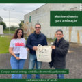A fotografia foi tirada em frente ao prédio principal do Instituto Federal Catarinense – Campus São Francisco do Sul. Ao fundo, há uma parede clara com a logomarca do IFC e a inscrição: “Instituto Federal de Educação, Ciência e Tecnologia Catarinense – Campus São Francisco do Sul”. O céu está nublado e o ambiente externo é arborizado, com gramado e árvores pequenas. No centro da imagem, estão três pessoas sorrindo em pé: • À esquerda está Gislaine Durski, uma mulher jovem de cabelos castanhos e soltos veste uma camiseta branca com o nome “GISLAINE DURSKI” em letras vermelhas e segura uma folha impressa. • No centro está o Professor Adalto Aires Parada, um homem de óculos, cabelo curto, e trajando jaqueta azul e calça jeans, segura uma ecobag bege com o logotipo do IFC campus São Francisco do Sul. • À direita está Marcos Aurélio Fernandes, um homem de óculos e cabelos curtos, usando sobretudo preto, segura a mesma ecobag junto com o homem do centro. Sobre a imagem, à direita, há um bloco verde com os dizeres: "Mais investimento para a educação". Na parte inferior da imagem, em uma faixa verde, está escrito: “Campus recebe entrega simbólica de emenda parlamentar.” Abaixo, em fundo verde-escuro: saofranciscodosul.ifc.edu.br