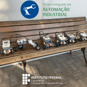 Robôs construídos pelos alunos alinhados sobre um banco de madeira, lado a lado. Cada robô é feito com peças tipo LEGO e possui rodas e sensores, mostrando a diversidade de modelos criados pelos estudantes. A imagem enfatiza a prática manual e a criatividade aplicada na construção dos robôs. O logotipo do curso está na parte superior e o do IFC campus São Francisco do Sul no inferior.