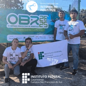 Quatro estudantes posam em frente a um banner da OBR 2025 – Etapa Santa Catarina, segurando uma bandeira do Instituto Federal Catarinense – Campus São Francisco do Sul. Dois estão em pé e dois estão agachados, todos usando camisetas brancas do campus. Estes estudantes são a equipe "Autofonia" que participou da competição. O logotipo do curso está na parte superior e o do IFC campus São Francisco do Sul no inferior.